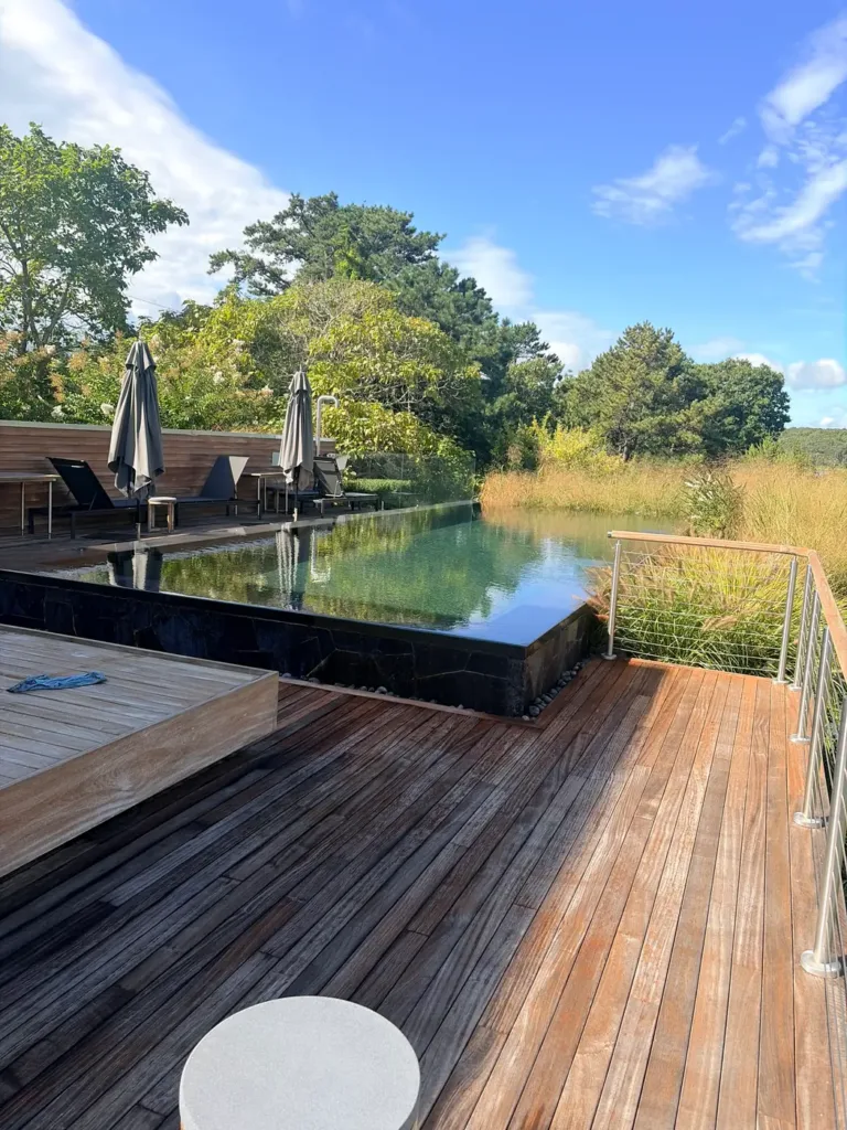 Wood deck surrounding a reflecting pool beside outdoor seating.